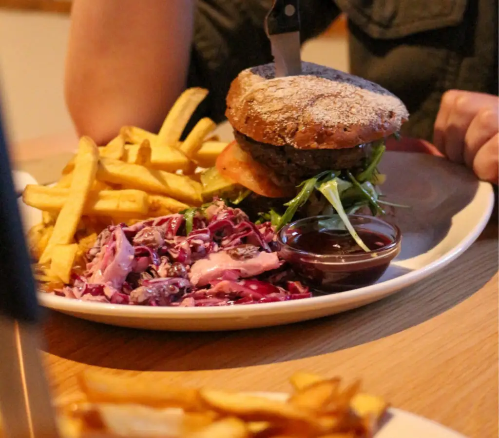 Burger op bord met frieten en coleslaw